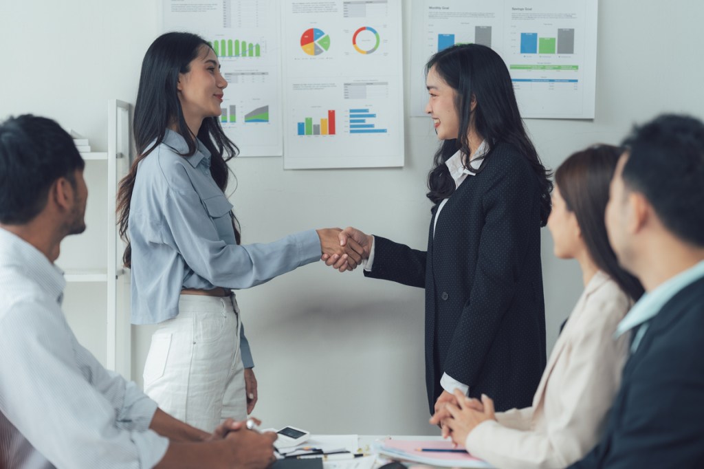 businesswomen with a firm handshake at a meeting symbolizing partnership or collaboration