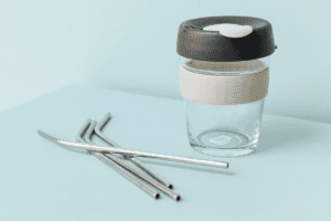 Drink Container and Metal Straws against a Blue Background