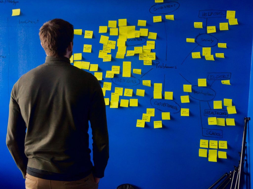 an event planner looking at a board full of event ideas written on post-its