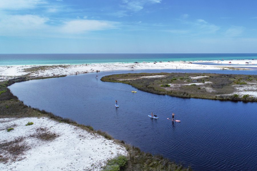 Enjoying a favorite bleisure activity, stand-up paddle boarders take in the views on Western Lake, one of the world's rare coastal dune lakes.