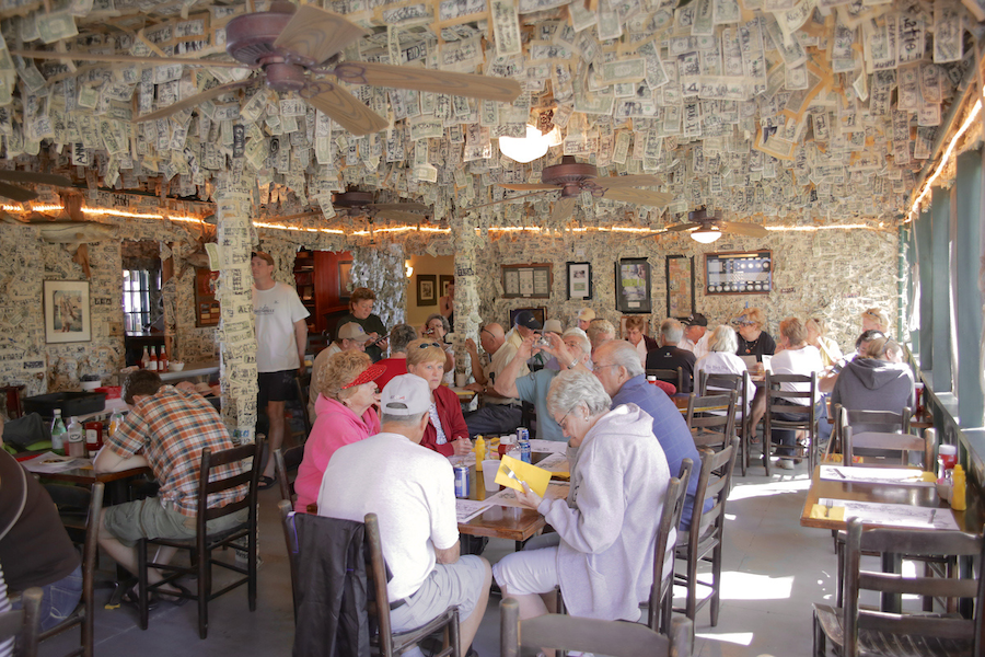 Approximately 30 inner guests sit around multiple tables inside the Dollar Bill Bar, a character-filled pitstop that will add whimsy to any coastal meeting.