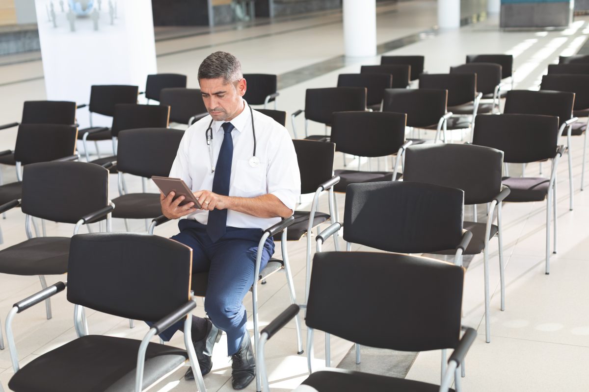 male doctor sitting in empty meeting room