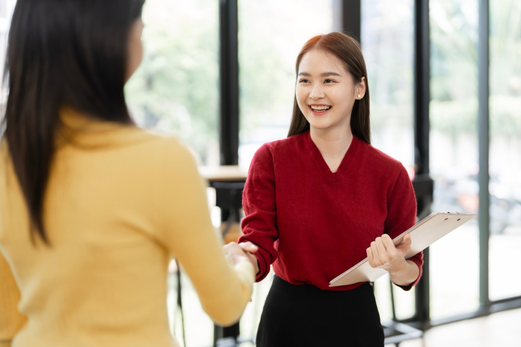 young event planner shaking hands with interviewer for a job interview