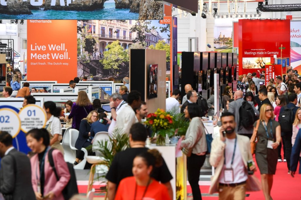 Photo of people walking on red carpet with trade show booths around them